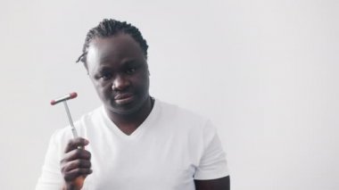 Tıbbi refleks çekici tutan Afrikalı siyahi bir adam. Beyaz arkaplanda izole