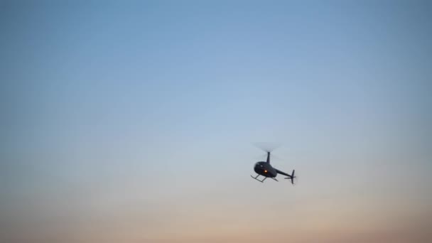 Вертолет летит в голубом небе — стоковое видео