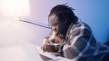 Yüksek ateşi olan Afrikalı Amerikalı siyahi bir adam doktorla online istişare yapıyor. Covid-19 dizüstü bilgisayar kullanan pozitif kişi