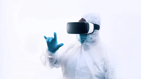 Unrecognizable doctor with vr glasses and full protective uniform touching air with finger. Robotic surgery simulation — Stock Photo, Image