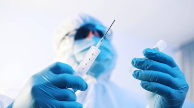 Covid-19 'a karşı aşı ve aşı. Üniformalı doktor aşıyı hazırlıyor.