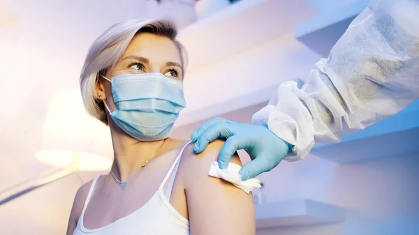 Medico che disinfetta il braccio della donna con garza di cotone. Vaccinazione contro il merluzzo bianco19 — Foto Stock