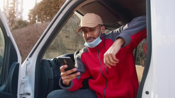 Kierowca z maską pod brodą za pomocą smartfona — Wideo stockowe