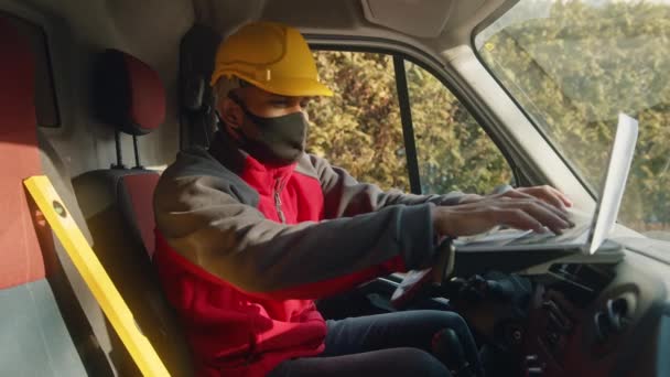 Homem com capacete e máscara facial usando tablet e ferramenta nivelador na van — Vídeo de Stock