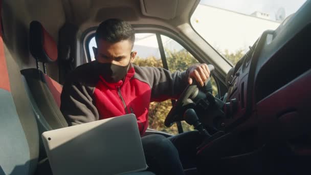 Young man looking at the laptop and starting the engine of the van — Stock Video