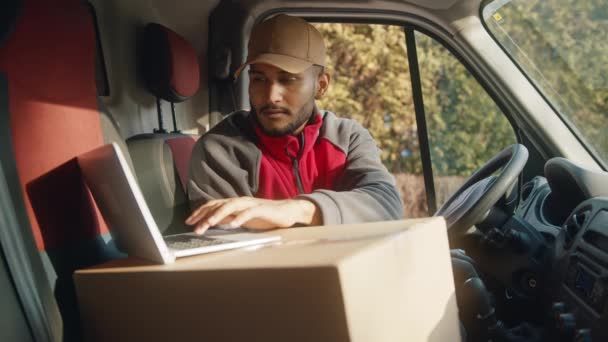 Mensajero usando el portátil en la furgoneta para confirmar la dirección de entrega — Vídeos de Stock