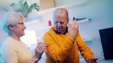 Otel odasında disko ışıklarıyla dans eden mutlu yaşlı çift. Sevgililer Günü ya da yıldönümü kutlaması