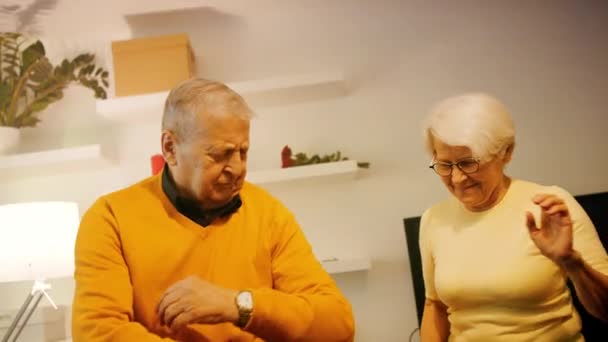 Glückliches altes Ehepaar tanzt mit Discolicht im Hotelzimmer. Valentinstag oder Jubiläumsfeier — Stockvideo