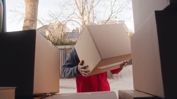 Νεαρός διανομέας που φορτώνει κουτιά από χαρτόνι στο φορτηγό — Αρχείο Βίντεο