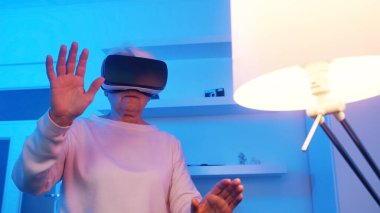 VR gözlük takan emekli yaşlı bir kadın. Sanal gerçeklikteki bir şeyden korkuyorsun. 