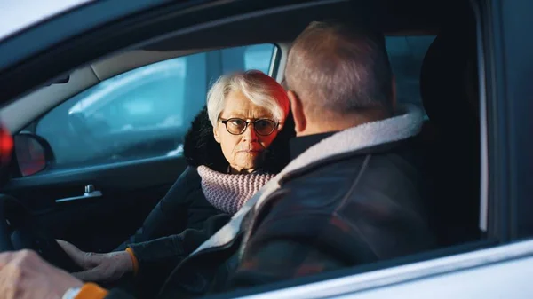 Elderly couple in the car confused with flashing police lights. Speeding ticket