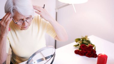 Ofiste makyaj yapan yaşlı bir kadın.