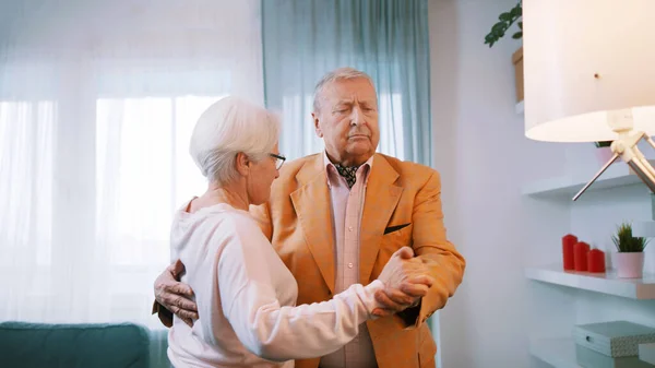 Happy elderly couple dancing at home . Love and dating at old age