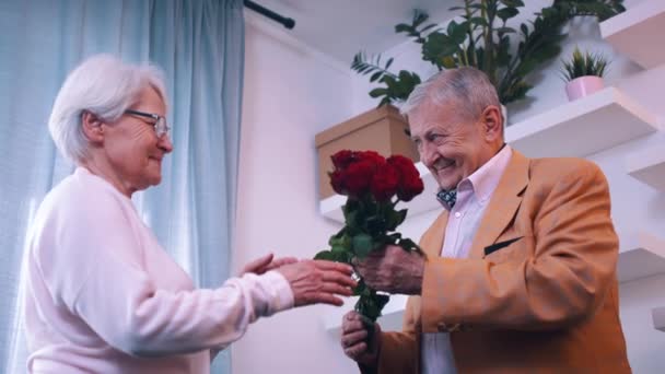 Amor e felicidade. Homem idoso dando rosas vermelhas para sua esposa no dia dos namorados — Vídeo de Stock