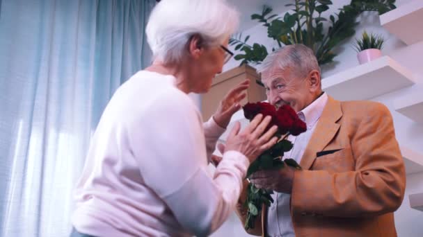 Αγάπη και ευτυχία. Ηλικιωμένος άνδρας δίνει κόκκινα τριαντάφυλλα στη σύζυγό του την ημέρα του Αγίου Βαλεντίνου — Αρχείο Βίντεο