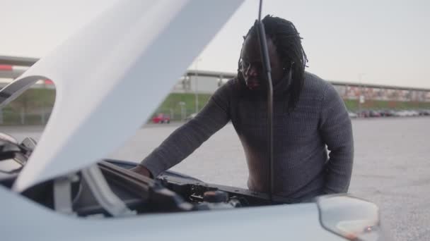 Homme noir afro-américain déprimé essayant de réparer la voiture cassée sur la route — Video
