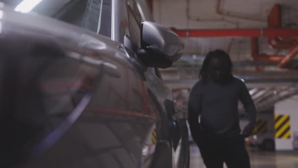 Triste afroamericano nero sconvolto che si avvicina e sblocca la sua auto piuttosto che sedersi sul sedile del conducente in un parcheggio fuori terra — Video Stock