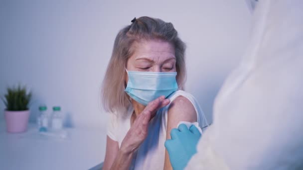 Vaccinering av utsatta personer under covid pandemi. Gammal kvinna som får vaccin — Stockvideo