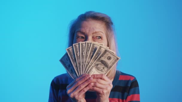 Retrato de una anciana amigable con un fan de billetes de dólar — Vídeos de Stock