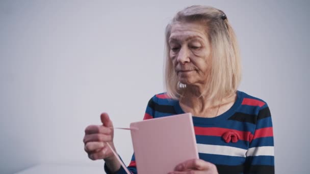 Elderly woman opening her diary and reading from it — Stock Video