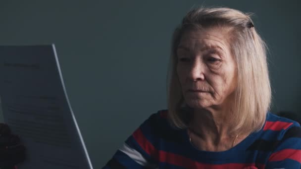 Oudere vrouw die het doktersrapport leest. Positieve test op covid19 — Stockvideo