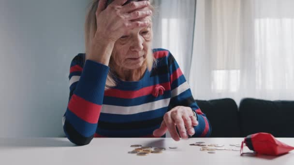 Arme alte Frau, die Münzen auf dem Tisch zählt. Hoffnungslose ältere Dame mit finanziellen Problemen — Stockvideo