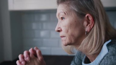 Bunalımlı yaşlı kadın yerde tek başına oturuyor ve düşünüyor