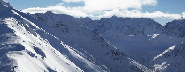 Malownicze Snowy Mountains przed błękitnym niebem z białymi chmurami Sezon zimowy — Zdjęcie stockowe