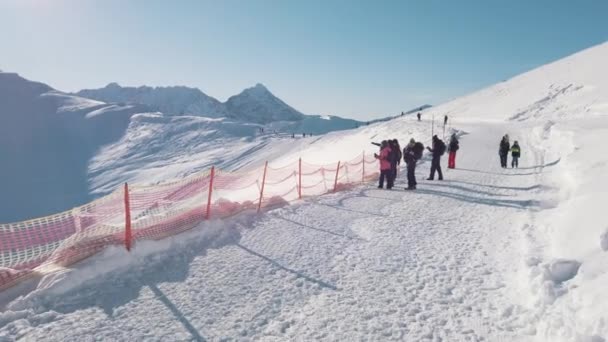 Groupe de personnes sur un paysage enneigé prenant des photos de montagnes enneigées — Video