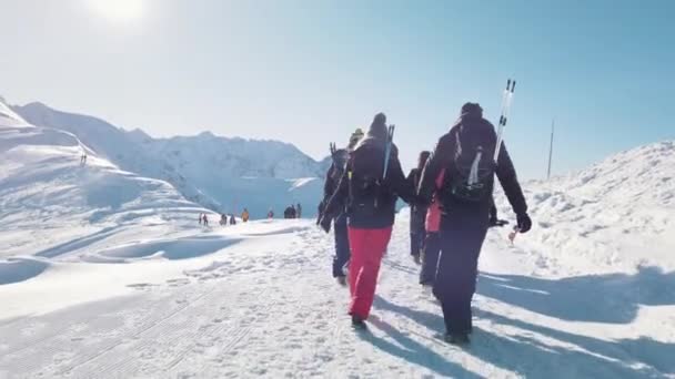 Groupe de randonneurs avec sacs à dos se dirigeant vers le sommet de la montagne enneigée — Video