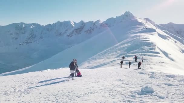눈덮인 산등성이 의 관광객들은 봉우리를 향해 이동하고 있다. 눈덮인 산들 — 비디오