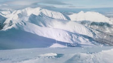 Kış mevsiminde karlı bir manzara. Bulutlu gökyüzüne karşı karla kaplı dağlar