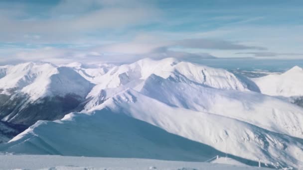 Schneebedeckte Berge in der Winterlandschaft mit wolkenlosem blauem Himmel tagsüber — Stockvideo