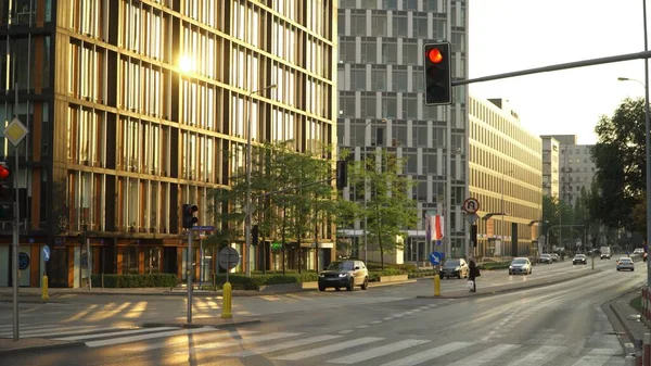 Rua Domaniewska vazia em Varsóvia, Polônia. Luz de sinal vermelho e reflexo dourado do sol nos edifícios — Fotografia de Stock