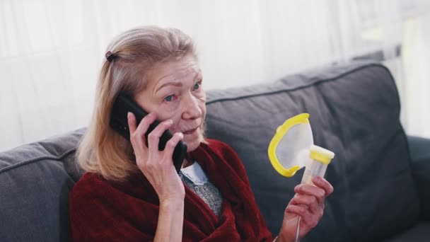 Einsame Seniorin mit Sauerstoff-Inhalator und Telefongesprächen. Covid19-Pandemie — Stockvideo