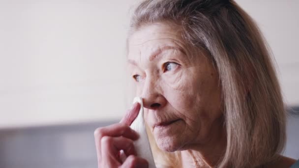 Surullinen vanha nainen pyyhkii kyyneleitään kudoksella. Yksinäisyys vanhuudessa käsite — kuvapankkivideo