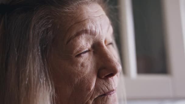 Anciana solitaria parpadeando y girando la cabeza para mirar atrás. — Vídeos de Stock