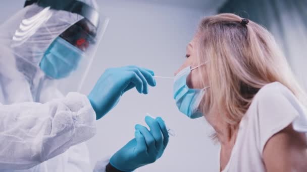 Médecin noir en uniforme complet effectuant un écouvillonnage nasal covid tes sur une femme âgée — Video