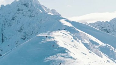 Kışın karlı dağlarda gündüz vakti bulutlu mavi gökyüzü