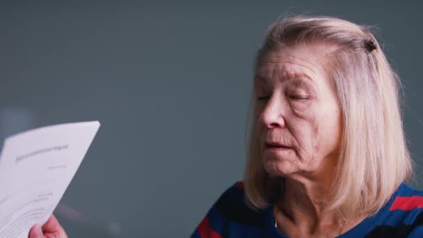 Teleurgestelde oude vrouw lezen document — Stockvideo