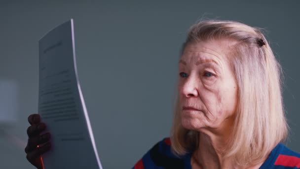 Hayal kırıklığına uğramış yaşlı kadın belge okuyor. — Stok video