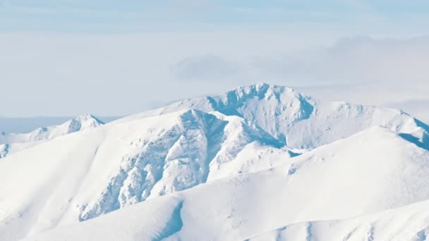 Schneebedeckte Berge in der Winterlandschaft mit wolkenlosem blauem Himmel tagsüber — Stockvideo