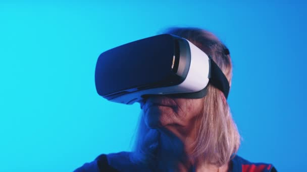 Γριά γκριζομάλλα γυναίκα που χρησιμοποιεί ακουστικά VR — Αρχείο Βίντεο