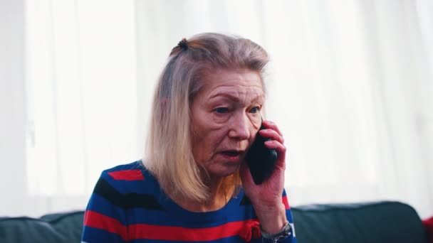 Desesperada mujer anciana preocupada teniendo una llamada telefónica — Vídeo de stock