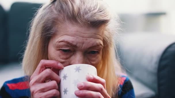 Ensam ledsen gammal kvinna dricker varm dryck — Stockvideo