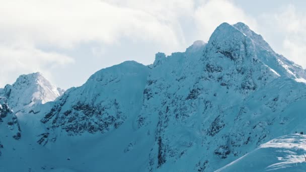 Сніговий пейзаж в зимовий сезон. Засніжені гори на фоні хмарного неба — стокове відео