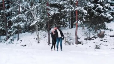 Genç çift, hiç bitmeyen karla kaplı ormanın önünde selfie çekiyor. 