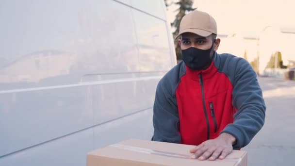 Kurýr doručující balíky během covid19, Muž v masce při nošení krabic — Stock video