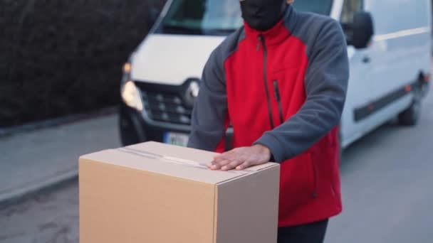 Mensajero entregando paquetes durante covid19, Hombre usando máscara mientras lleva cajas — Vídeos de Stock