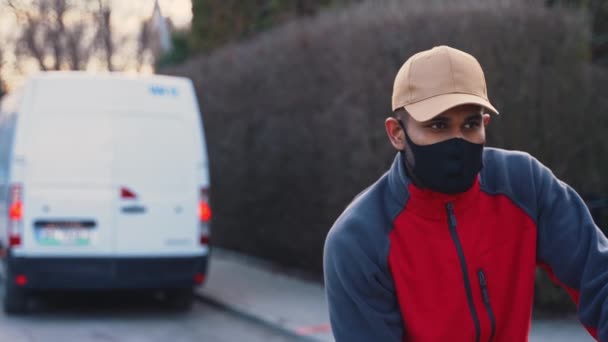 Homme avec masque facial poussant chariot avec des boîtes en carton. livraison de marchandises en cas de pandémie — Video